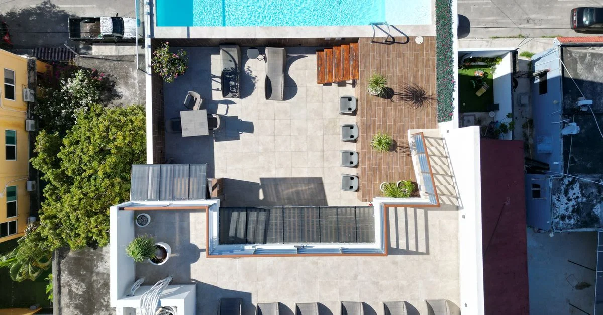 Toma aérea de una lujosa terraza en el techo con piscina en Playa del Carmen, mostrando arquitectura moderna.