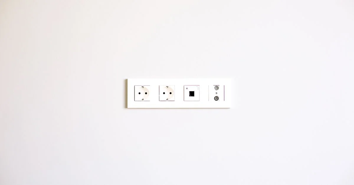 Una imagen minimalista que muestra un conjunto moderno de enchufes en una pared blanca brillante.