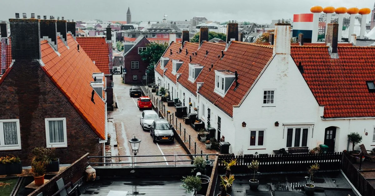 Vista aérea de un pintoresco barrio holandés con sus emblemáticos tejados de tejas rojas y su encantadora arquitectura.