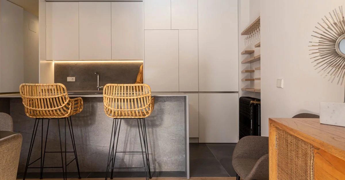 Cocina minimalista y elegante en Madrid con un diseño sleek y sillas de ratán.